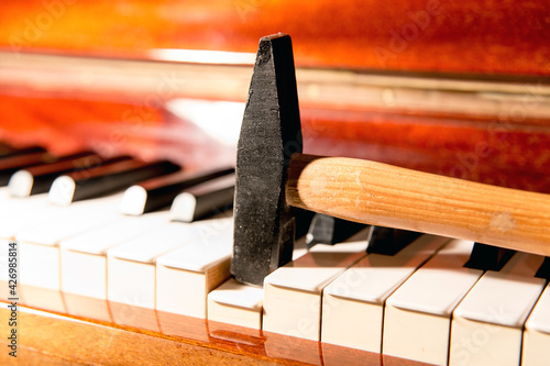 Close up of a small hammer pushing a key of a piano down. Noise and bad sound concepts.