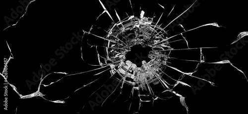 Bullet hole in the glass. Isolated on a black background.