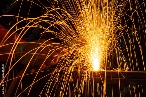 Iron welding close-up, sparks do not wear gloves. Welding sparks and fumes It can be dangerous to health.