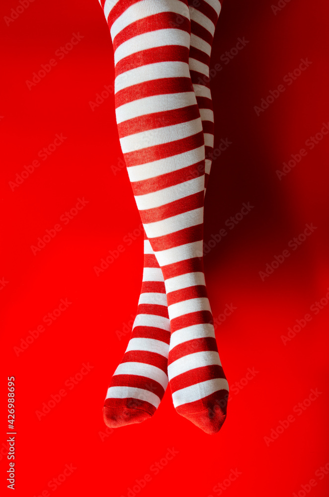 Christmas concept. Santa woman legs on red background Christmas concept. Santa woman legs on red background