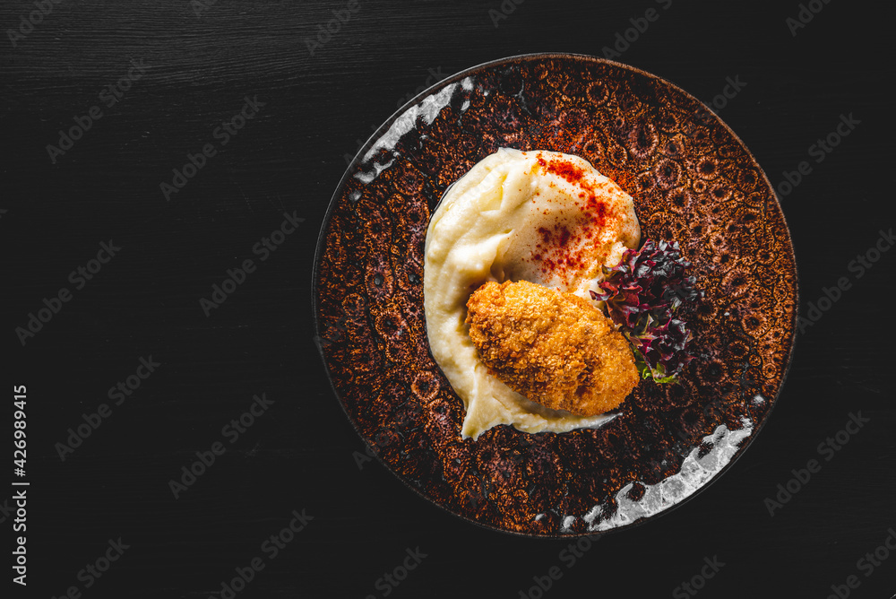 burger with mashed potatoes in white on black wooden background burger with mashed potatoes in white on black wooden background