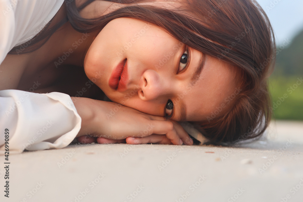 Portrait of asian women lying on the beach with sunset at krabi province,Thailand. Beautiful asian girl travel in the summer. Portrait of asian women lying on the beach with sunset at krabi province,Thailand. Beautiful asian girl travel in the summer.