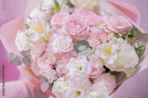 A bouquet of light pink  white cute delicate different flowers of different sizes  roses  green leaves. Romance