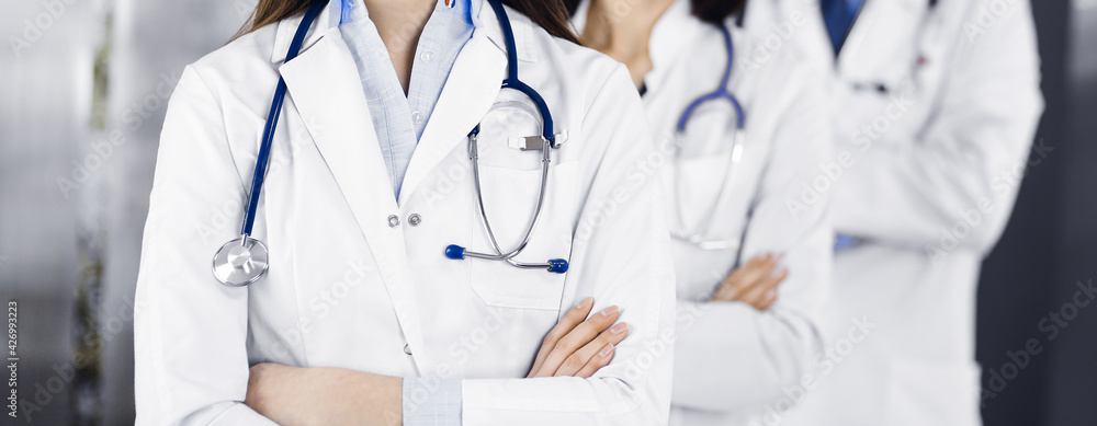 Group of professional doctors is standing as a team with arms crossed in clinic. Medicine concept during Coronavirus pandemic Group of professional doctors is standing as a team with arms crossed in clinic. Medicine concept during Coronavirus pandemic