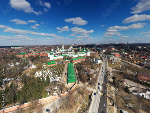 a panoramic view of the golden towers and ancient architectural solutions of the Trinity-Sergius Lavra in Sergiev Posad on a sunny spring day filmed from a drone 