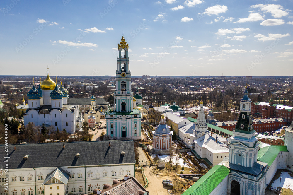 a panoramic view of the golden towers and ancient architectural solutions of the Trinity-Sergius Lavra in Sergiev Posad on a sunny spring day filmed from a drone 