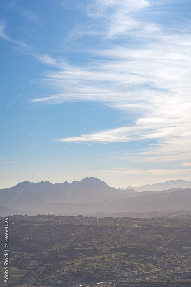 Obraz premium Mountain between villages on a clear day with few clouds, the sea in the background. In Alicante, Spain.