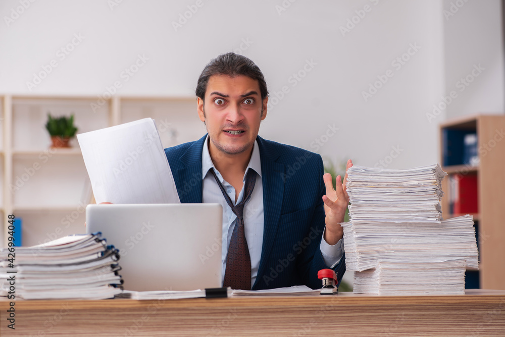 Young male employee unhappy with excessive work Young male employee unhappy with excessive work
