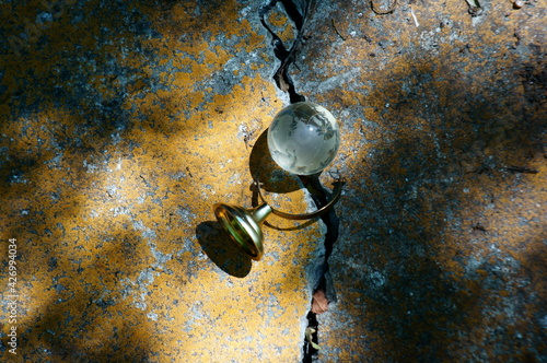 A small glass globe against a crack in the wall.