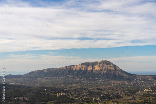 Mountain between villages on a clear day with few clouds, the sea in the background. In Alicante, Spain. Montgo Massif Natural Park