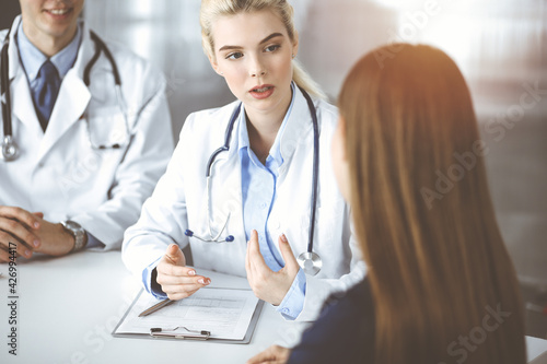 Wallpaper Mural Woman-doctor with male colleague are consulting patient woman while sitting at the desk in modern clinic. Perfect medical service, medicine concept Torontodigital.ca