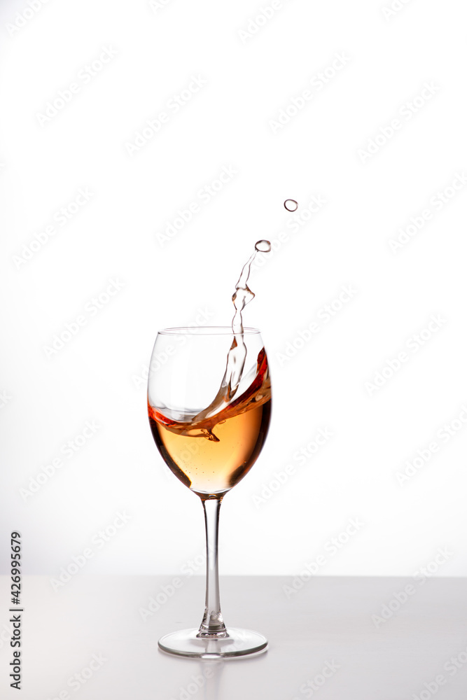 Wein im Weinglas mit spritzer aus dem Glas Wein im Weinglas mit spritzer aus dem Glas