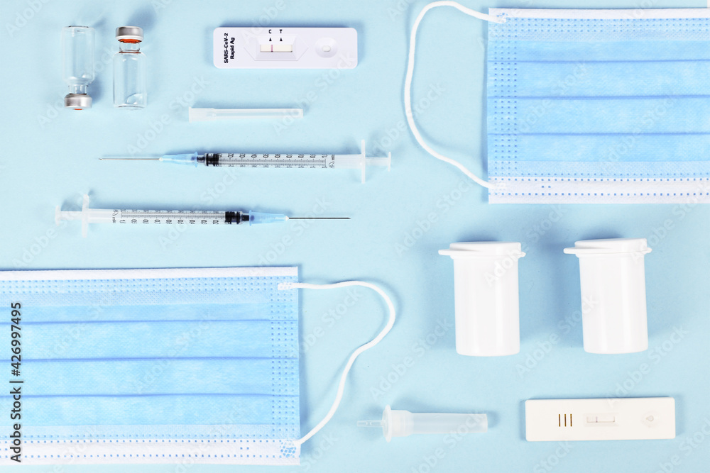 Rapid antigen test, medical face masks, vaccine vials with syringe and medication bottles. Tools to fight Corona Virus pandemic Rapid antigen test, medical face masks, vaccine vials with syringe and medication bottles. Tools to fight Corona Virus pandemic