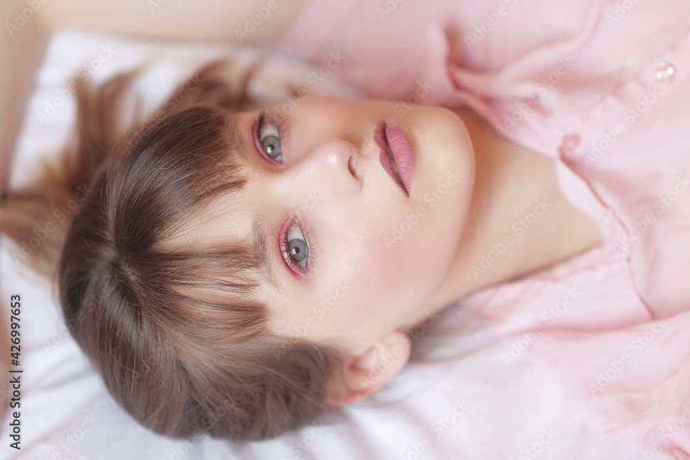 Adolescente aux yeux bleu allongée sur un lit Adolescente aux yeux bleu allongée sur un lit