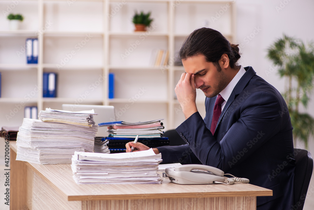 Young male employee unhappy with excessive work Young male employee unhappy with excessive work