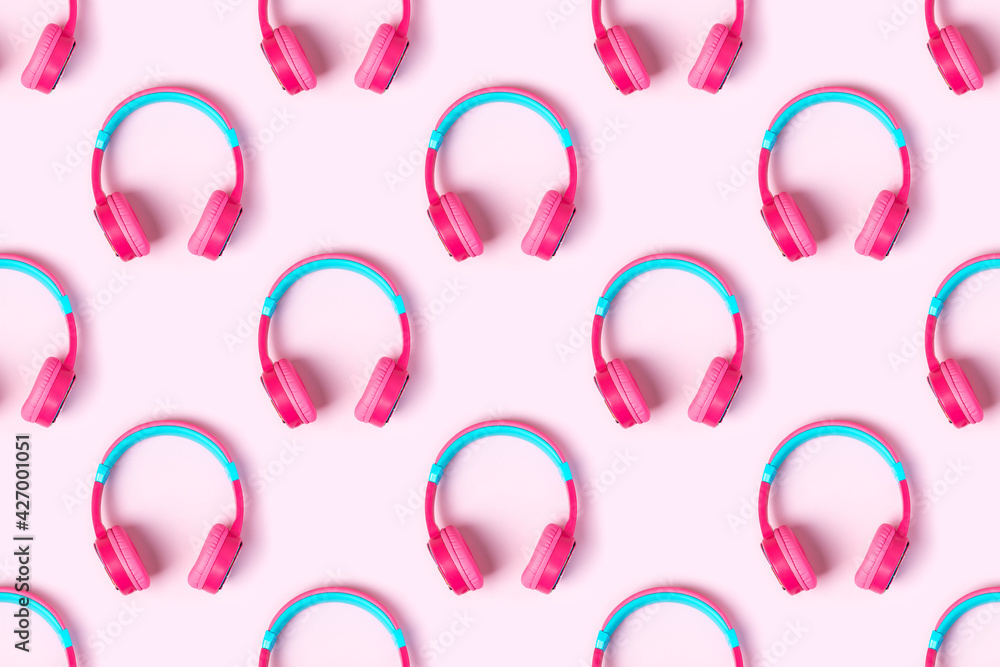 Seamless pattern of pink and light blue headphones on pink background. Minimalistic fashion music concept. Top view, flat lay
