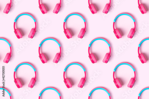 Seamless pattern of pink and light blue headphones on pink background. Minimalistic fashion music concept. Top view, flat lay