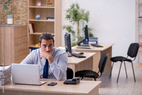 Young male employee sitting in the office