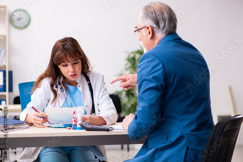 Old businessman visiting young female doctor © Elnur