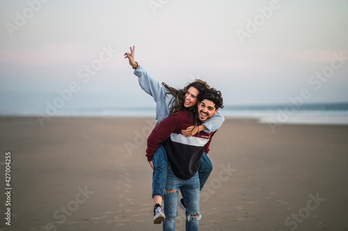 Pareja de chico y chica juntos en la playa sonriendo y pasandolo bien photo