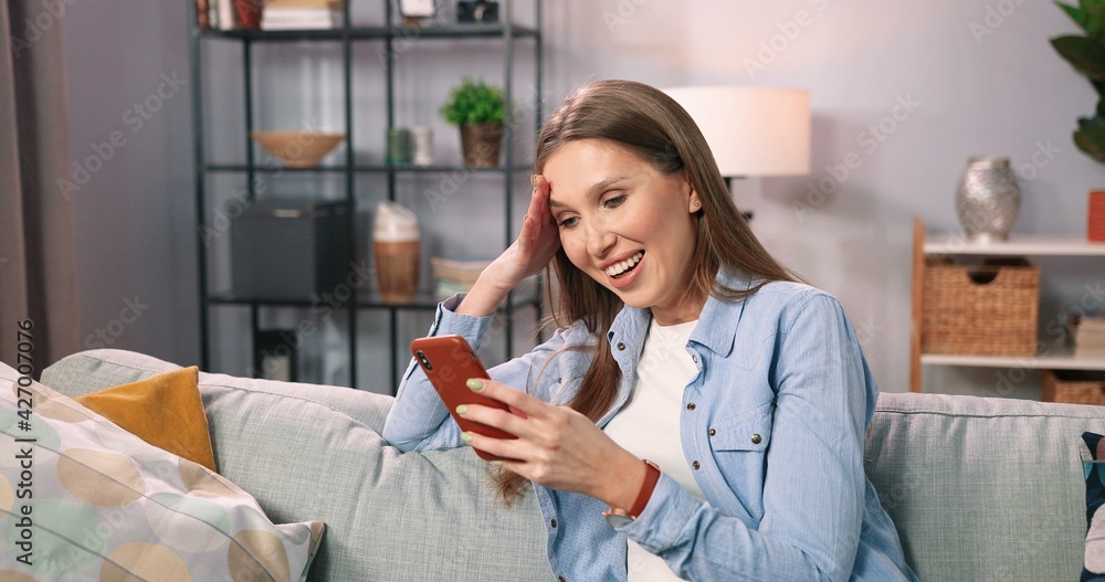 Portrait of surprised young girl looking at phone screen. Amazed overjoyed millennial woman reading sms with unexpectable news with opened mouth. Online lottery win concept Portrait of surprised young girl looking at phone screen. Amazed overjoyed millennial woman reading sms with unexpectable news with opened mouth. Online lottery win concept