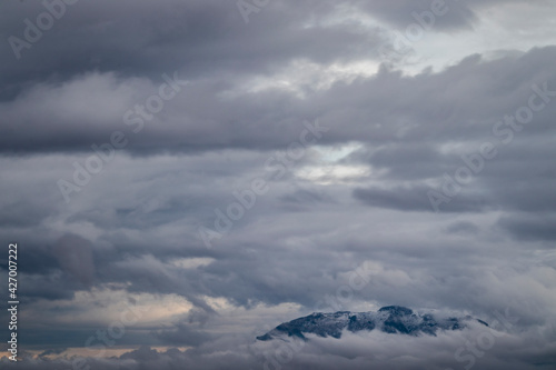 Winter photograph of a large mountain surrounded and isolated by the dense clouds of those days when Filomena was lurking all over Spain.