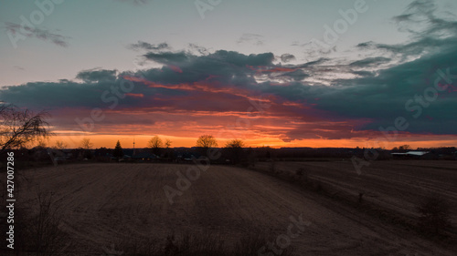 Sonnenuntergang über ein Feld in Schleswig Holstein mit starken orangenen Farben.