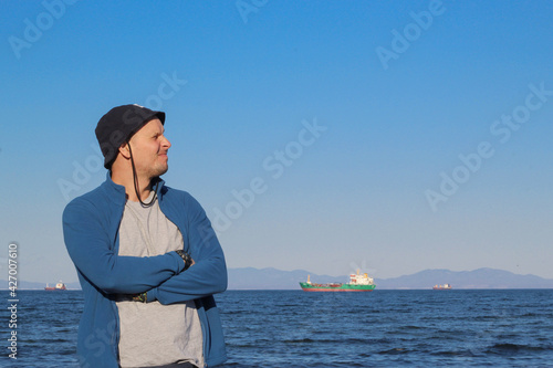 Obraz na płótnie A man in a hat against the backdrop of a seascape. w salonie