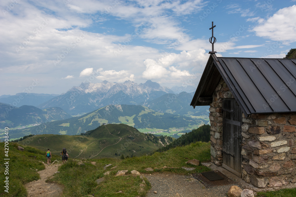 Little mountain chapel in the austrian mountain at daylight with mountain range in the background