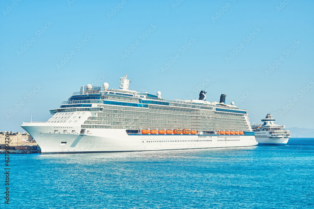 Large white tourist cruise ship on blue rippling sea