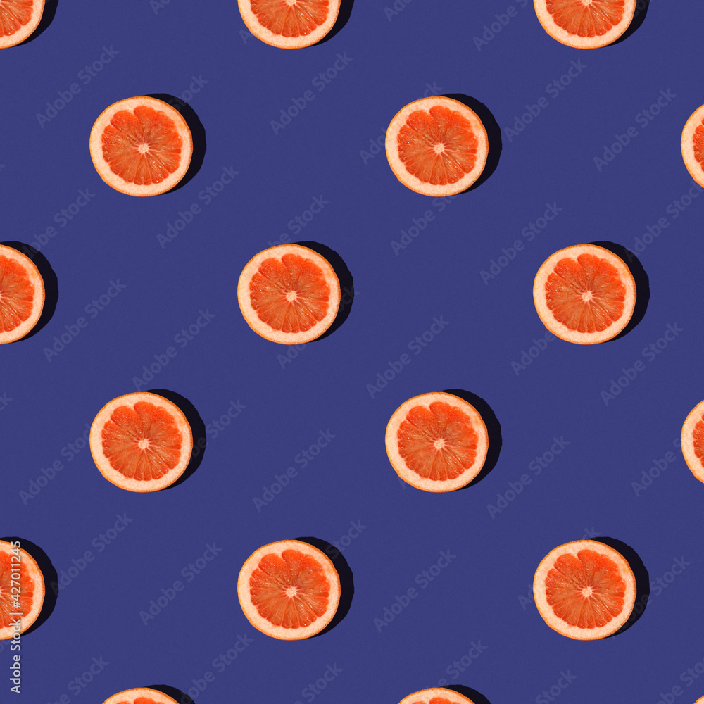 Trendy summer Seamless pattern of juicy orange mandarine tangerine grapefruit slice with shadow on bright blue background. Minimal summer rest concept. Pattern fabric print, wrapping paper design. Trendy summer Seamless pattern of juicy orange mandarine tangerine grapefruit slice with shadow on bright blue background. Minimal summer rest concept. Pattern fabric print, wrapping paper design.