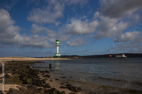Scenic view to a picturesque coastline with sand beach and light house by the Kiel Fjord.