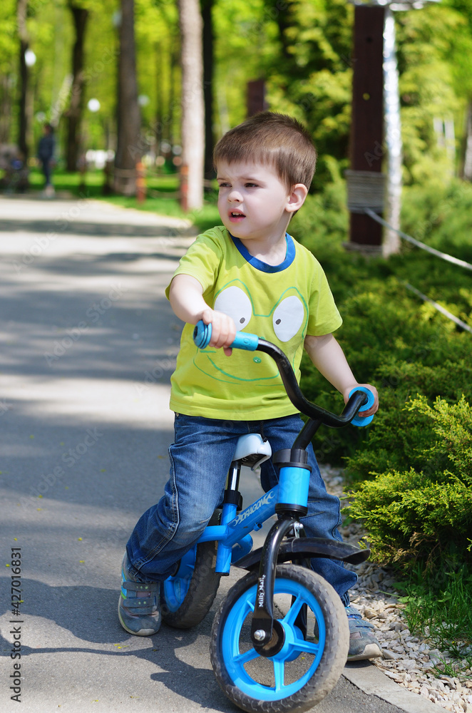 Happy family concept. Little cheerful boy playing in the park, playground and laughing on a spring walk on a sunny day. Family holiday and togetherness, selective focus. Happy family concept. Little cheerful boy playing in the park, playground and laughing on a spring walk on a sunny day. Family holiday and togetherness, selective focus.