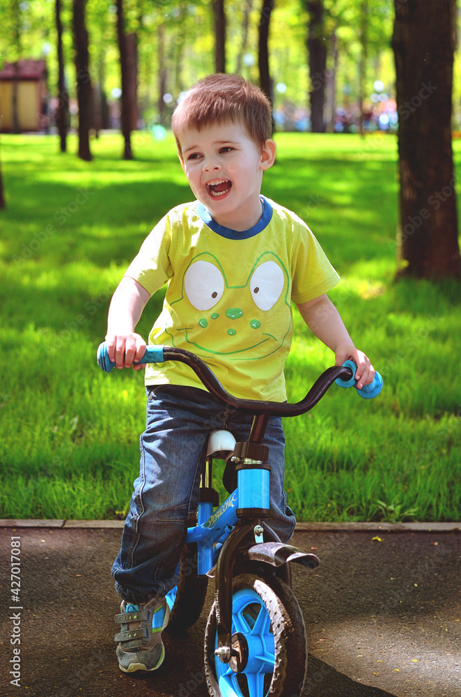 Happy family concept. Little cheerful boy playing in the park, playground and laughing on a spring walk on a sunny day. Family holiday and togetherness, selective focus. Happy family concept. Little cheerful boy playing in the park, playground and laughing on a spring walk on a sunny day. Family holiday and togetherness, selective focus.