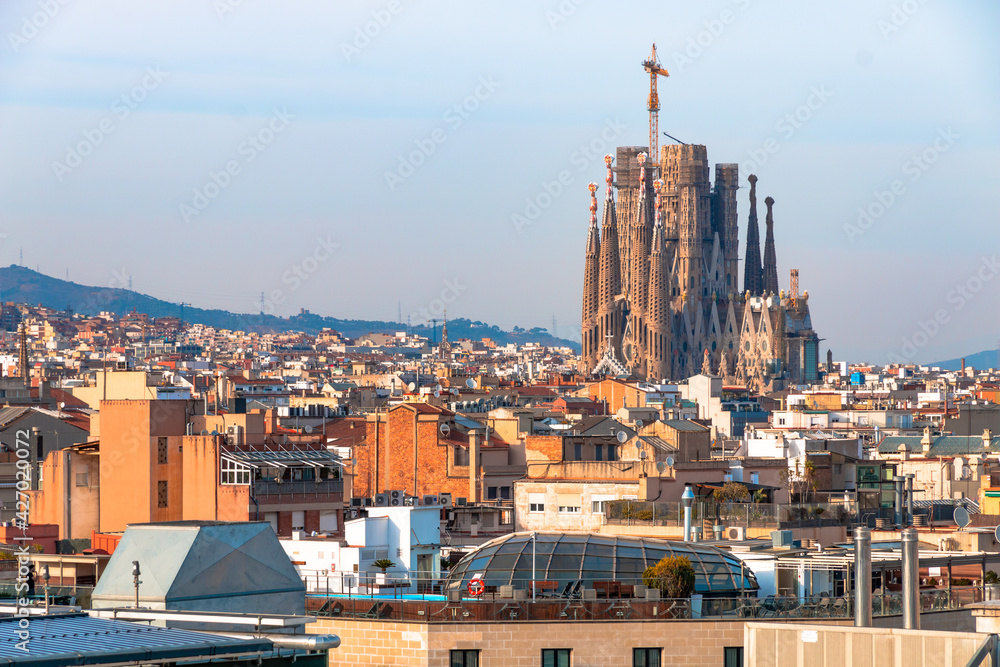 Picture of Sagrada Familia designed by Gaudí captured in a sunny day from a high building in Barcelona, Spain. 