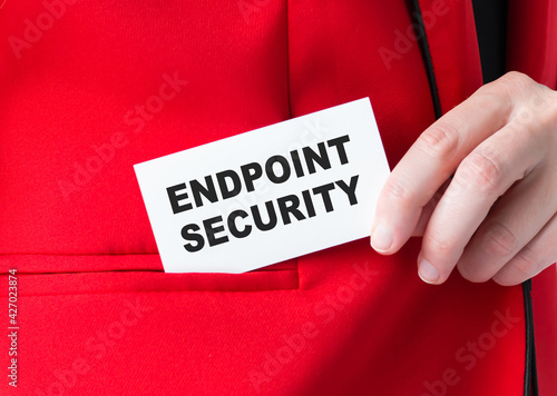 Endpoint security text on a white business card in the hands of a businessman, close-up.