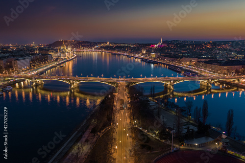 Budapest, Hungary - Aerial skyline panoramic view of illuminated Margaret Bridge at dusk. Parliament of Hungary, Szechenyi Chain Bridge and Buda Castle at background with clear golden and blue sky