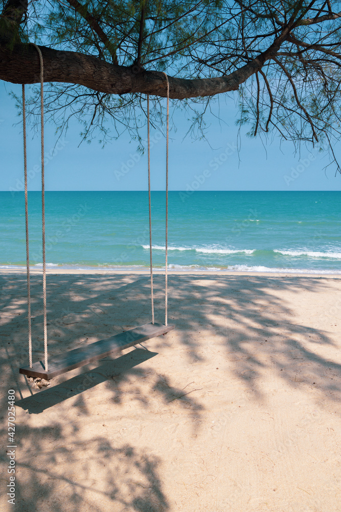 Turquoise blue sea view with swing at pine tree on beach, Nature background wallpaper