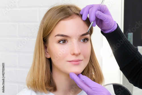 Young woman shaping eyebrows with brush