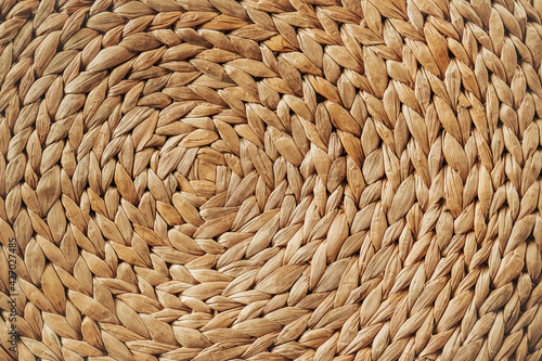 Woven rattan. Weaving circle pattern background. Detail and texture of traditional handicraft. Natural basketry material.
