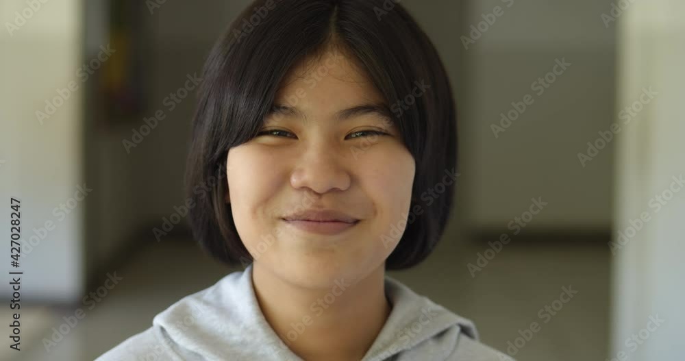 Slow motion scene of a cute young Asian teenage high school student girl is laughing happily and shyly. Slow motion scene of a cute young Asian teenage high school student girl is laughing happily and shyly.