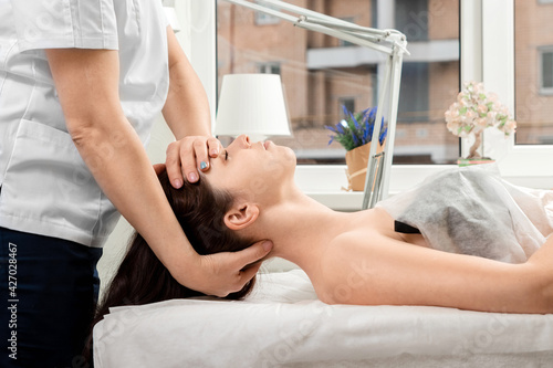A beautiful girl is doing a neck massage. Skin care, beautician, spa treatments, relaxation.