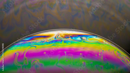 Fluid soap bubble looking like planets. Psychedelic colorful abstract art with urreal patterns of color in motion.