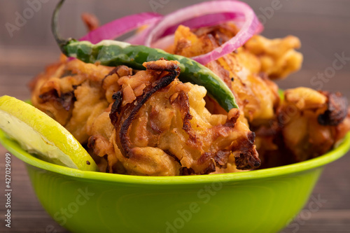 Onion Pakoda Also Known As Kanda Bhajji, Pyaj Ke Pakode, Pakoda, Pyaaj Pakore, Pakora, Pyaaz Bajji Is Enjoyed In Rainy Season Across North And South India. Served With Green Chutney And Ketchup Sauce photo