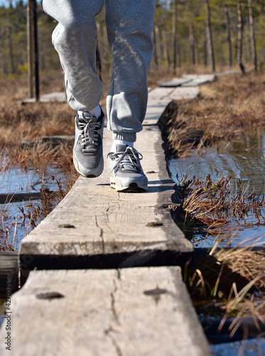A person walking along duckboards over very wet swamp