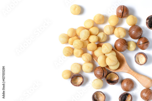 Peeled macadamia nuts in wood spoon isolated on white background,