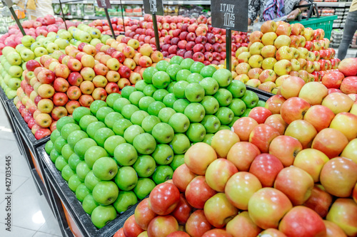 Different sorts of apples on the supermarket shelves in the fruit department