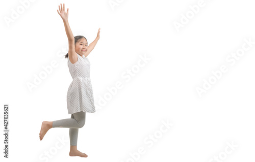 kid girl raise her hand and raise one leg isolated on white