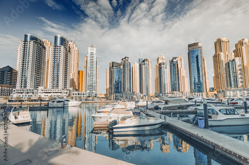 Photography yacht and motor boats parking at the port near Dubai Marina Mall with row of hig