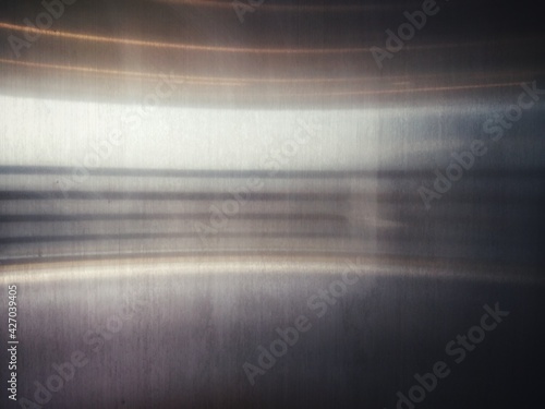 Stainless steel surface with a horizontal light curve.